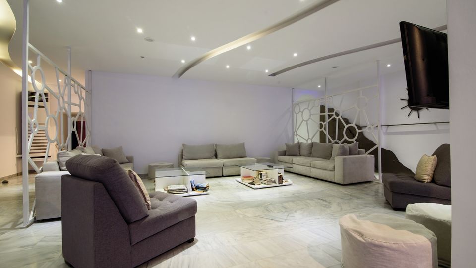 Großer Lounge-Bereich mit bequemen Sofas, modernen Raumteilern und stilvollem Deckenlicht – ideal zum Entspannen oder Lesen.