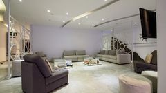Großer Lounge-Bereich mit bequemen Sofas, modernen Raumteilern und stilvollem Deckenlicht – ideal zum Entspannen oder Lesen.