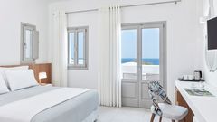 Helles und stilvolles Doppelzimmer im Costa Grand Resort & Spa – modernes Design in Weiß und Grau mit gemütlichem Bett, Arbeitsbereich und direktem Meerblick durch große Fenster.