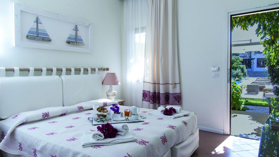 hell eingerichtetes Zimmer im Erdgeschoss im Hotel Palau auf Sardinien in Italien